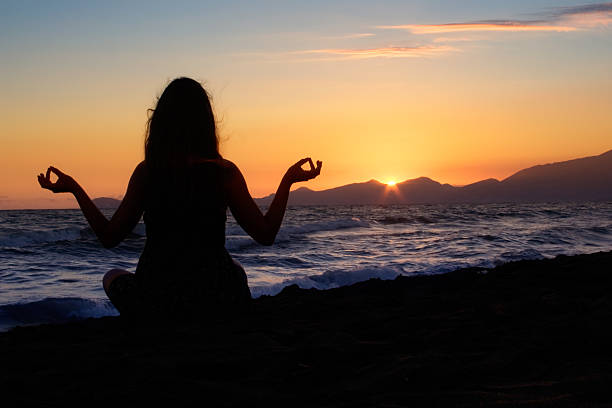 Meditando en la playa - foto de stock