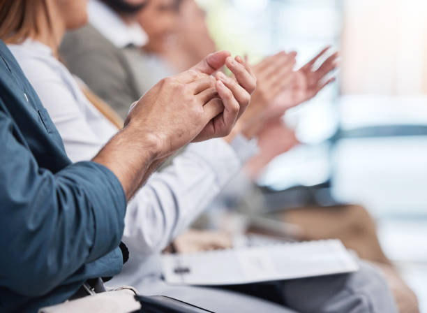 istock Unknown group of diverse businesspeople clapping in office training. Team of professional colleagues cheering and celebrating together while learning in workshop. Attending a seminar for marketing 1399605538