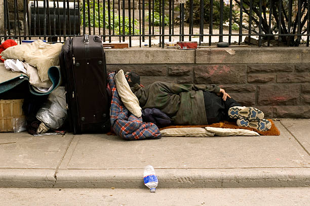 homeless sleeping Homeless person sleeping on the sidewalk with bags. homelessness stock pictures, royalty-free photos & images