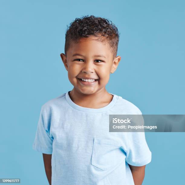 Portrait Of A Smiling Little Brown Haired Boy Looking At The Camera Happy Kid With Good Healthy Teeth For Dental On Blue Background Stock Photo - Download Image Now