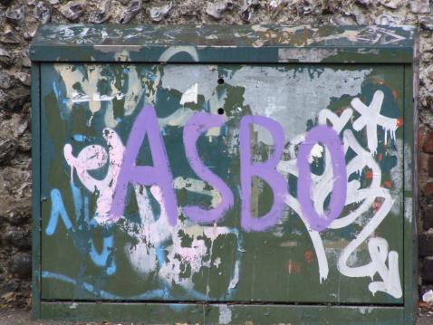 A telephone junction box daubed with graffiti. The box is situated outside the Brighton & Hove School in Hove, Sussex, England. The most prominent tag is \