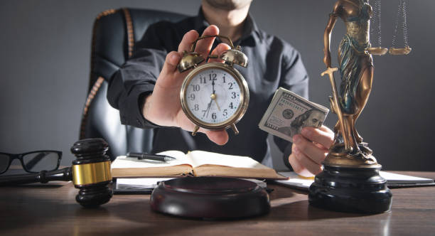 Male judge holding clock and money at courtroom. stock photo