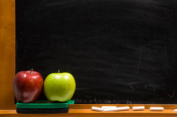 istock One red and one green apple in front of a chalkboard 139961844