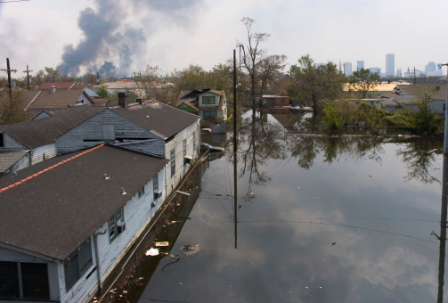 Flooded Lake Forest area of New Orleans, Louisiana after Hurricane Katrina with buildings burning uncontrolled in the background.