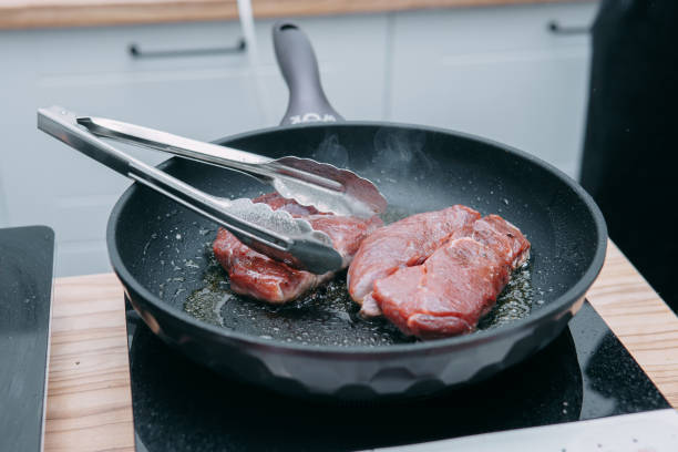 kochen von rinder-ribeye-steak in einer pfanne im kochkurs. steak mit gewürzen. kochprozess, nahaufnahme. - animal bone chop close up color image stock-fotos und bilder
