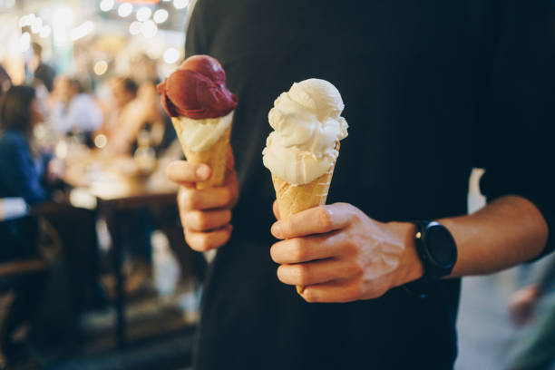 Man holding two ice cream cones at night summer festival stock photo