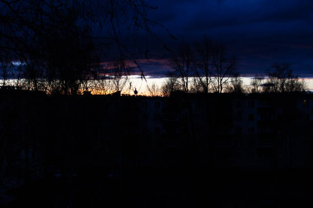 Bright streak of sunset in the dark night sky close up