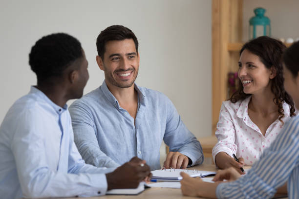 istock Happy diverse millennial employees talking at meeting table 1399627861