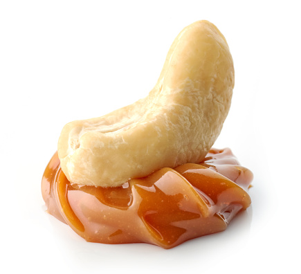 cashew nut in melted caramel isolated on white background
