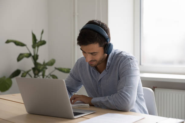 un étudiant positif écrivant des notes sur un ordinateur portable - domestic car audio photos et images de collection