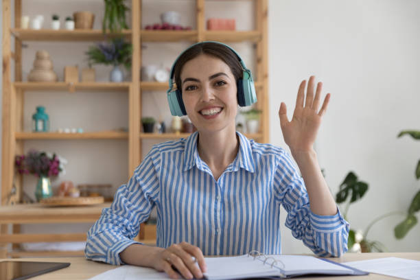 heureux jeune blogueur d’affaires dans les écouteurs sans fil donnant un webinaire - domestic car audio photos et images de collection