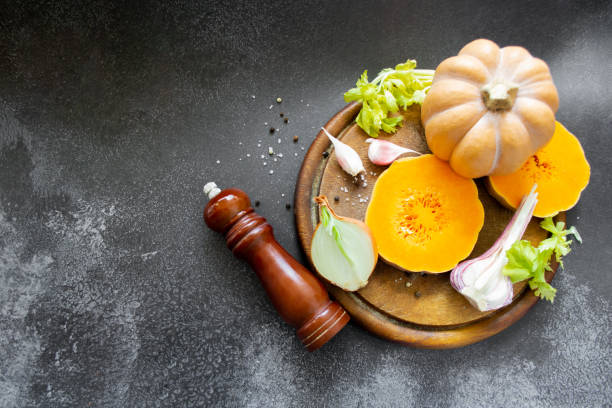 istock Vegetables: orange squash, garlic, onions. Spice mill, pepper, salt. Black background. Copy space 1399633322