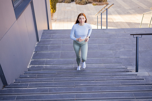 Healthy lifestyle sports woman running up on stone stairs