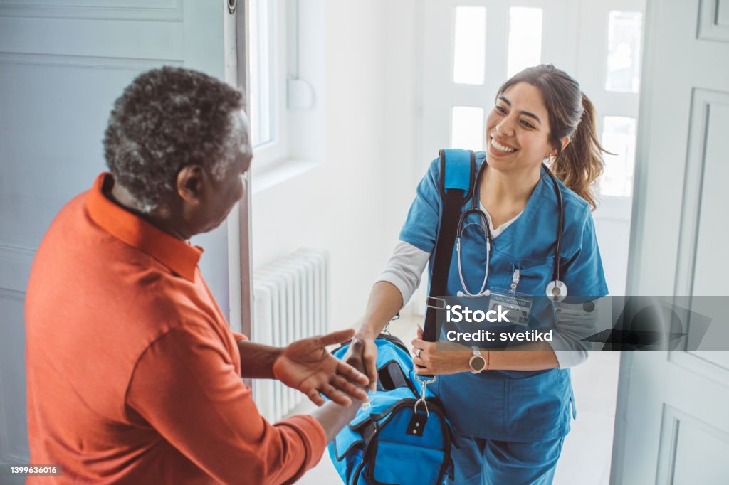 Home care for old people Nurse visiting mature patient at home. She is holding bag and entering at patient's home. Healthcare And Medicine Stock Photo