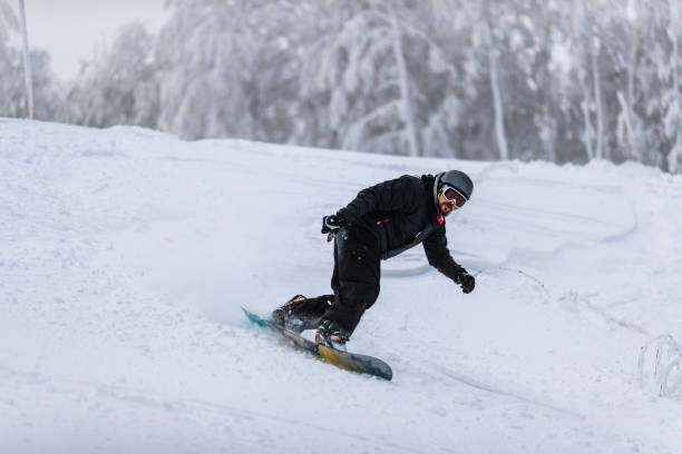 istock Skillful man snowboarding on a ski slope in winter day. 1399637518