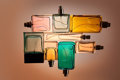 Top view, flat lay of a set of perfume bottles on a beige blank background.