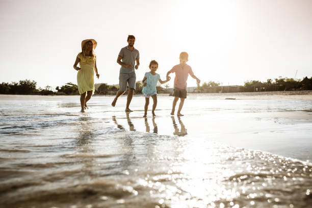 istock Young happy family chasing on the beach. 1399637900