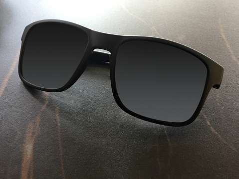 Black Sunglasses on a bright Background with Reflection and Transparency