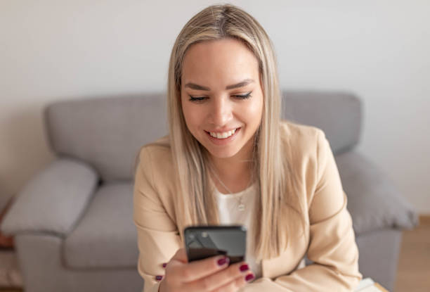 istock Happy charming woman using smartphone while working with laptop at home 1399638705