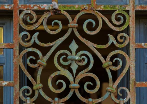 Old iron window grille. Rust, slime and the worn blue paint.