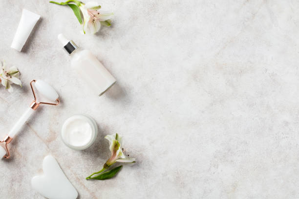istock Natural organic SPA beauty products on stone table. Flat lay face massage roller, serum, moisturizer cream, flowers. Skin care and treatment concept. 1399643420