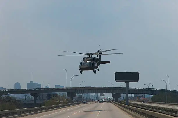Military Blackhawk helicopter takes flight from New Orleans' Interstate 10, evacuating stranded citizens after Hurricane Katrina.