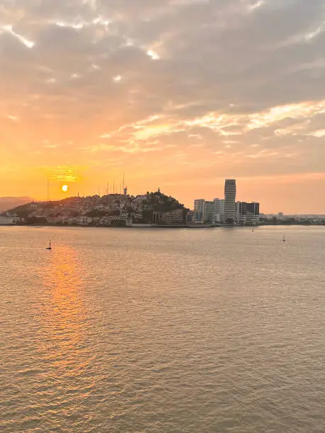 Coloful Cityscape of Guayaquil city at sunset with a view of Santa Ana Hill and part of the Malecon 2000 waterfront in front of the Guayas river and the point skyscraper. Guayaquil, Ecuador, Latin America, South America. Aerial Point of view.