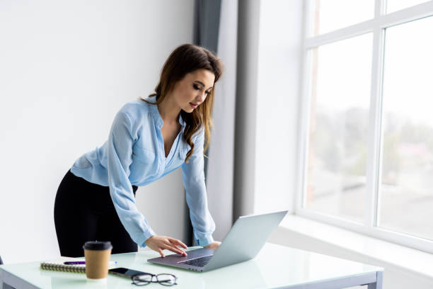 istock Young pretty woman working at lap top in the office. 1399646397