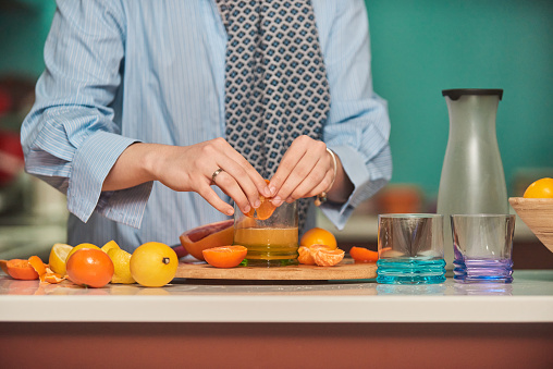 Arab hijab woman making fruit juice in the modern kitchen. Home concept. Healthy lifestyle concept. Selective focus. High quality photo.