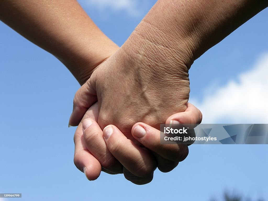 Holding Hands, Touching Hearts Mother and Daughter walking in the park holding hands Adult Stock Photo