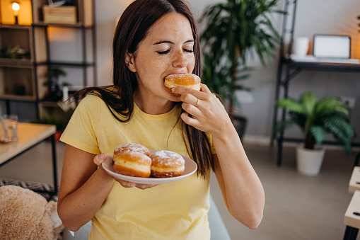 Closeup of woman eating doughnuts
