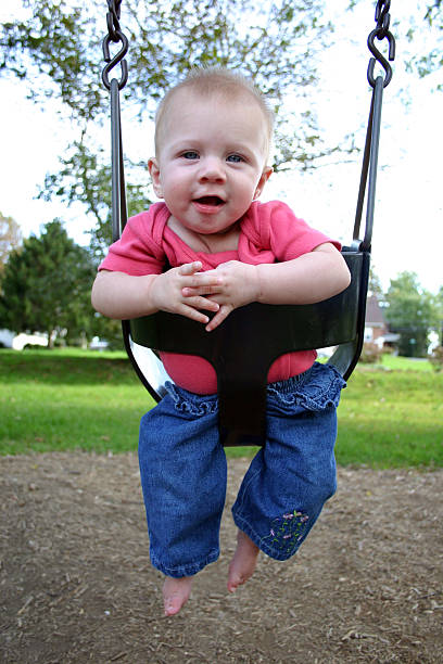 Baby in park swing stock photo