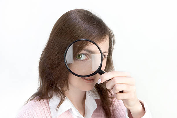 istock Young Woman with Magnifying Glass 139965095