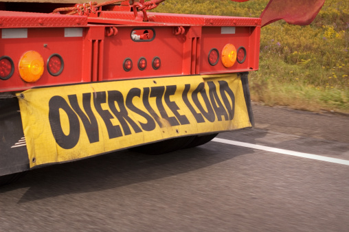 Oversize sign truck on a highway