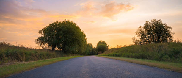istock country road among meadows colorful sunset on background 1399656000