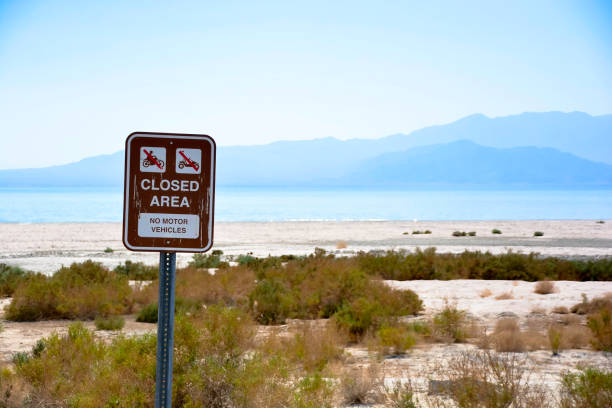 A closed area sign sits unread at a state recreation beach area that has been abandoned at the Salton Sea California.