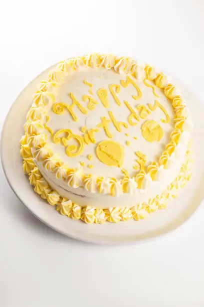 Lemon flavoured Happy Birthday Sponge cake with yellow decorative icing.