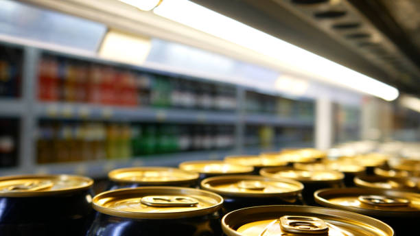 Close-up of many golden black cans of beer or energy drink on a store fridge shelf Many golden black cans of beer or energy drink on a store fridge shelf close-up grocery shelf cans stock pictures, royalty-free photos & images