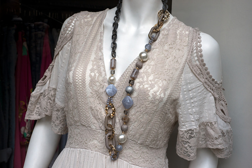 Closeup of beige boho style dress on mannequin in a fashion store showroom