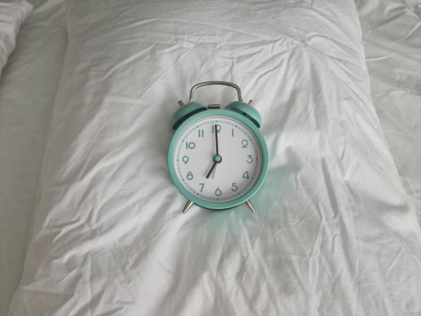 istock Alarm clock for seven o'clock on white pillow on bed 1399666615
