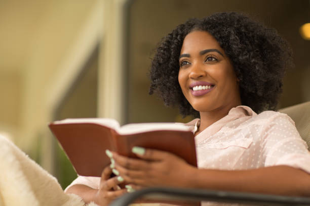 istock Woman smiling holding a book. 1399675566