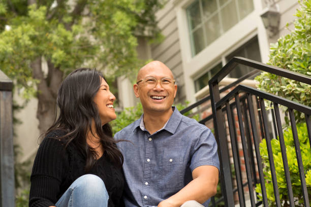 Happy Asian couple smiling and hugging outside. Portrait of an Asian couple smiling and hugging outside. common couple men outdoors stock pictures, royalty-free photos & images