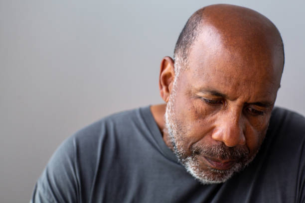 Portrait of a mature man looking sad and away from the camera. Mature African American man in deep thought looking unhappy. black man stock pictures, royalty-free photos & images