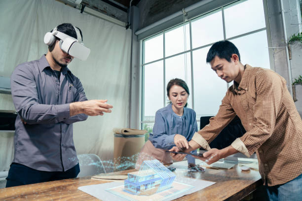 Architect team together design architectural building model with Virtual reality and Augmented reality technology working in office.