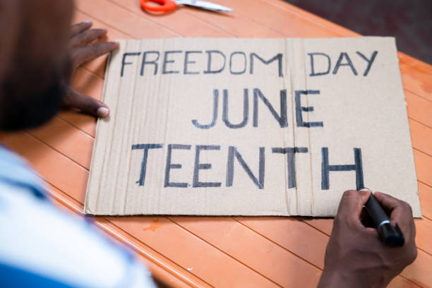 shoulder shot of activist preparing freedom day junteenth sign board for marching - concept of independence and campaign - juneteenth celebration 個照片及圖片檔
