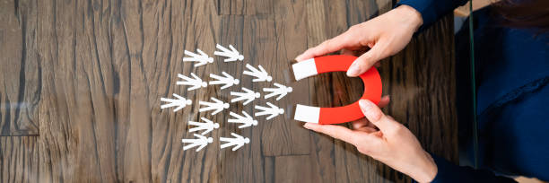 istock Human Hand Attracting Red Human Figures With Horseshoe Magnet 1399683151
