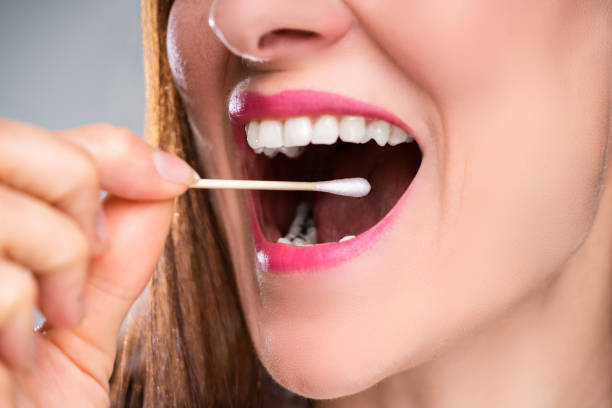 istock Dentist's Hand Taking Saliva Test From Woman's Mouth 1399683225