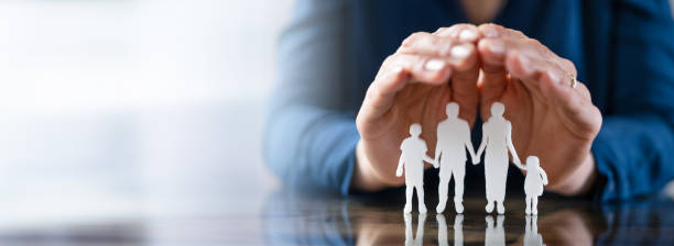 istock Businessperson's Hand Protecting Family Figures 1399683500
