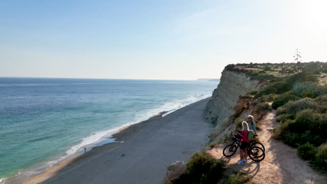 Aerial view of bicycling couple on coastal headland