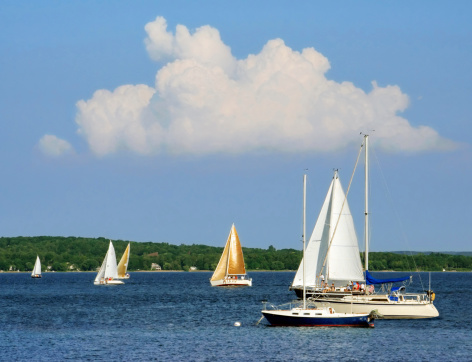 A variety of boats entering and leaving Falmouth Harbor in Falmouth, MA on Cape Cod.  A Busy harbor, there is a constant flow of boats including the Island Queen ferry out of the harbor into Vineyard Sound.